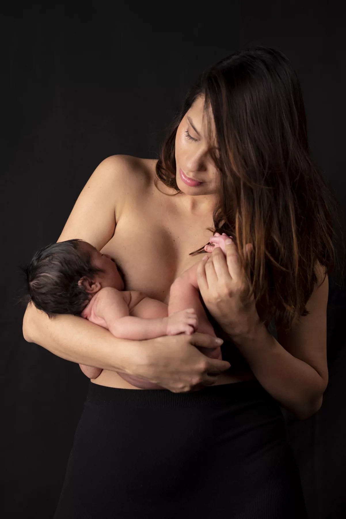 Embarazada desnuda dando la mama al niño